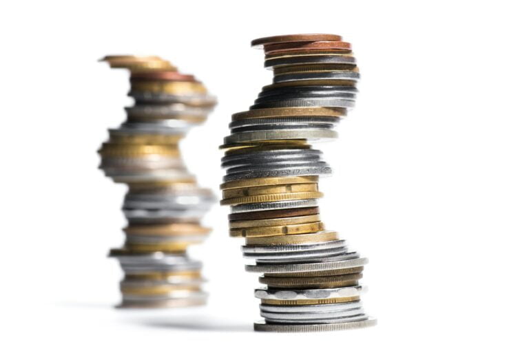 selective focus of stack of different coins isolated on white