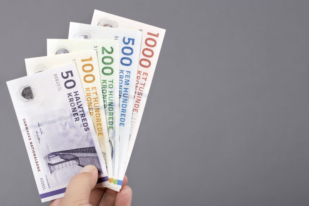 Danish money in the hand on a gray background