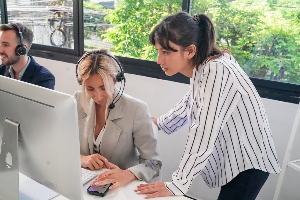 Charming business lady in headphones talking with business partner on laptop