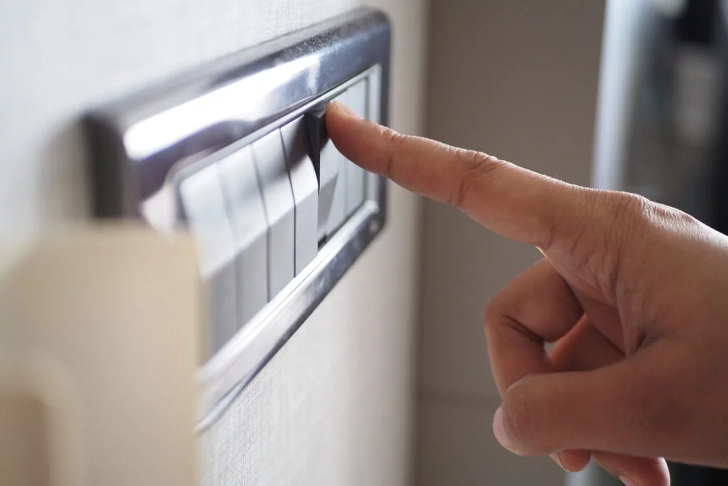 A finger turning on lighting switch .